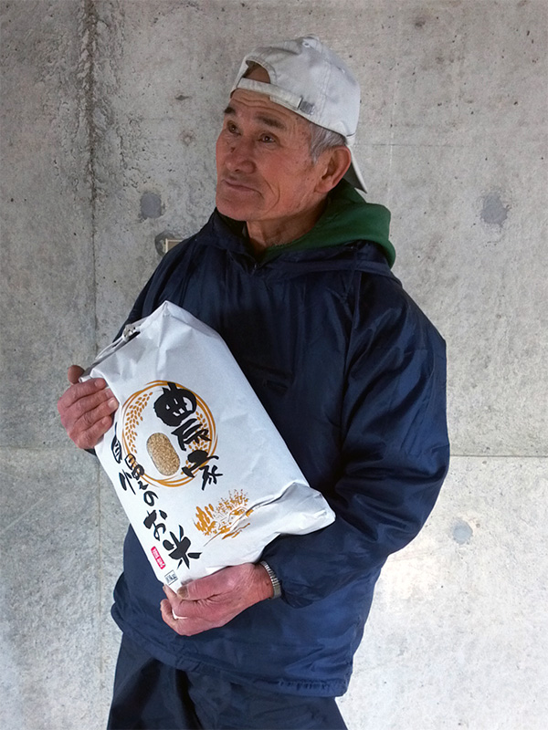 無事収穫できたおいしいお米を大事に抱える梅沢代表
